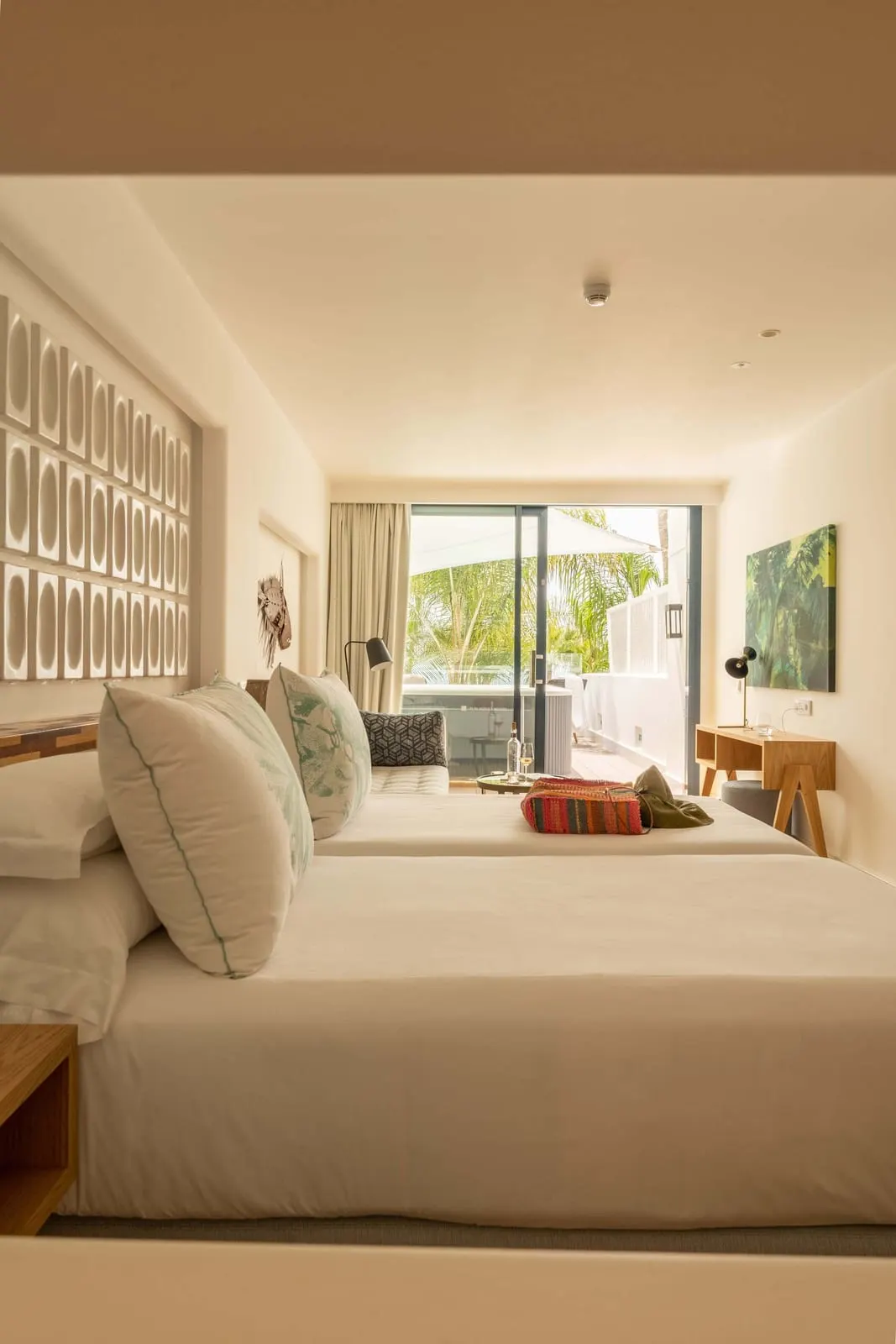 Junior Suite Relax Sea View at Hotel Fariones: a bed with a woven headboard wall and a glass door leading out to the terrace