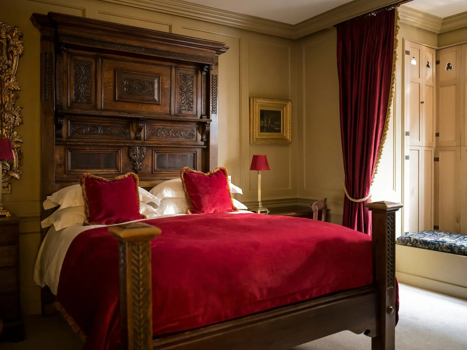 Superior Double al Hazlitt's: un letto con testiera in legno intagliato, un copriletto rosso e una seduta sotto la finestra dietro le tende