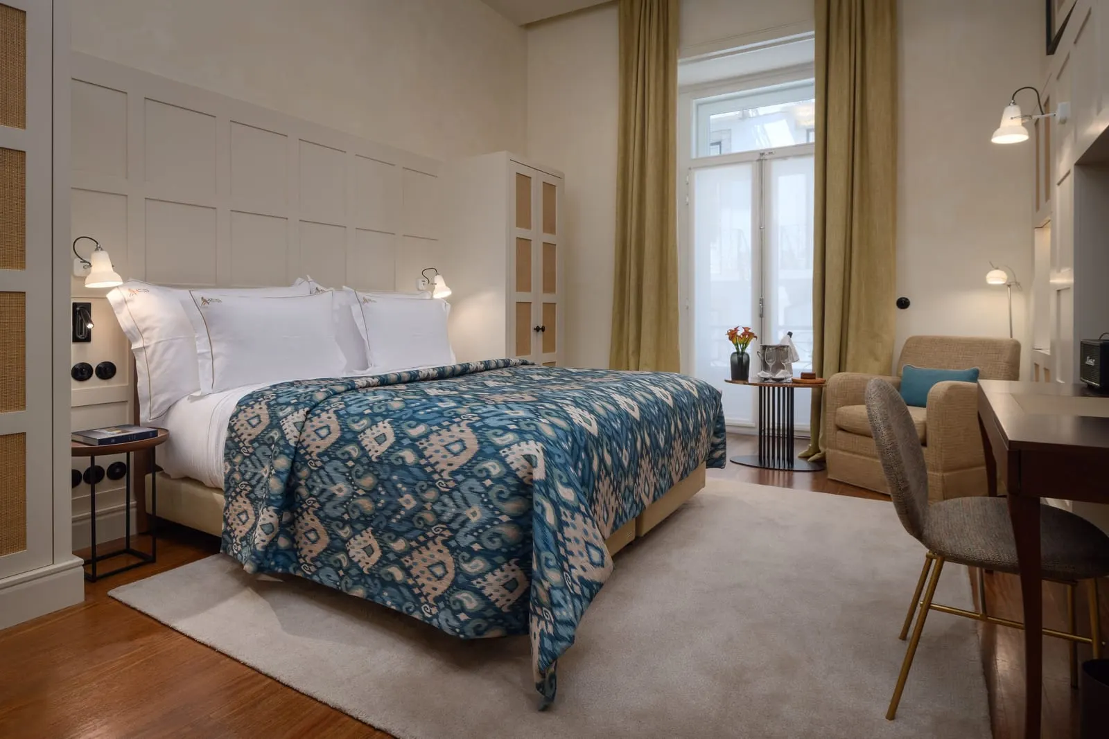 Classic Chiado room at Bairro Alto Hotel: a double bed with a blue throw, an armchair, a desk and a tall window