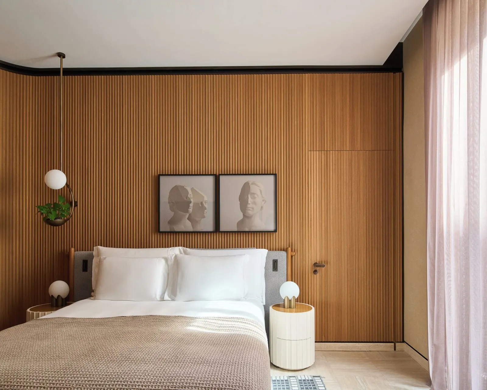 Deluxe room at Six Senses Rome: a double bed against a slatted wood wall, with two framed prints above