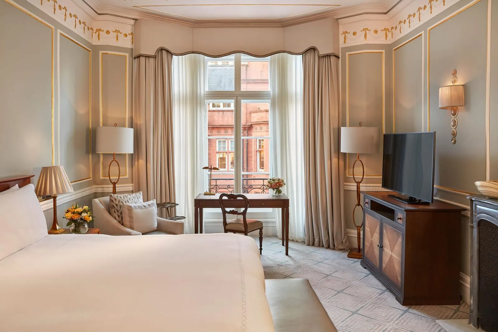 Claridge's Room at Claridge's: the bed, an armchair, a writing desk under a tall window and a television