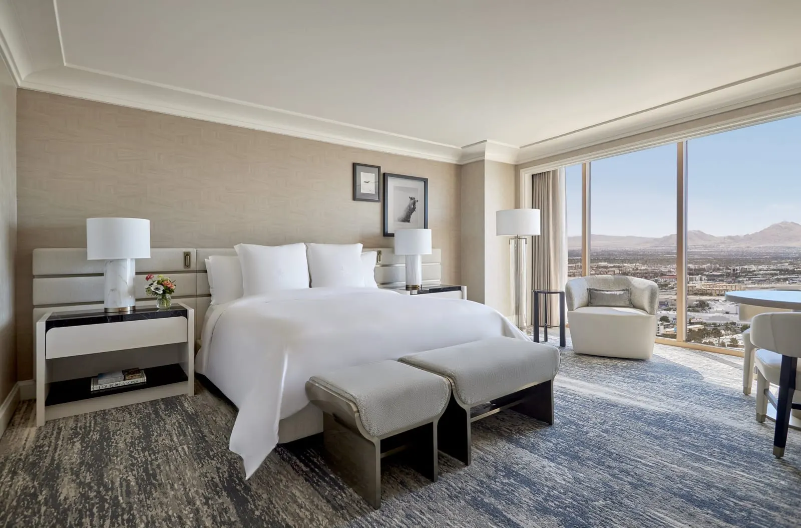 Superior Room at Four Seasons Hotel Las Vegas: a king bed with a two-part bench at its foot, an armchair and a round table by floor-to-ceiling windows