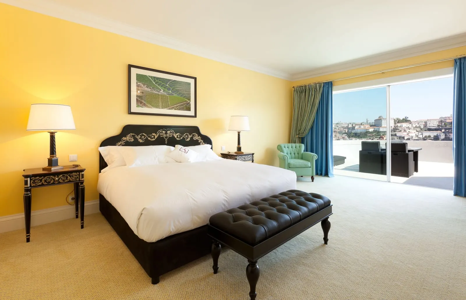 Superior Deluxe Panoramic Room at The Yeatman: the bed, an armchair and sliding doors to a furnished terrace facing the city
