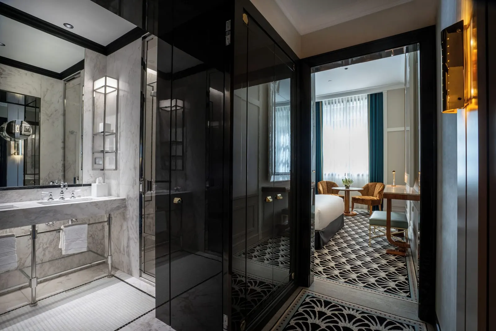 Superior Room at The One Monumental Palace: the marble bathroom and glass shower, with the bedroom and its window beyond