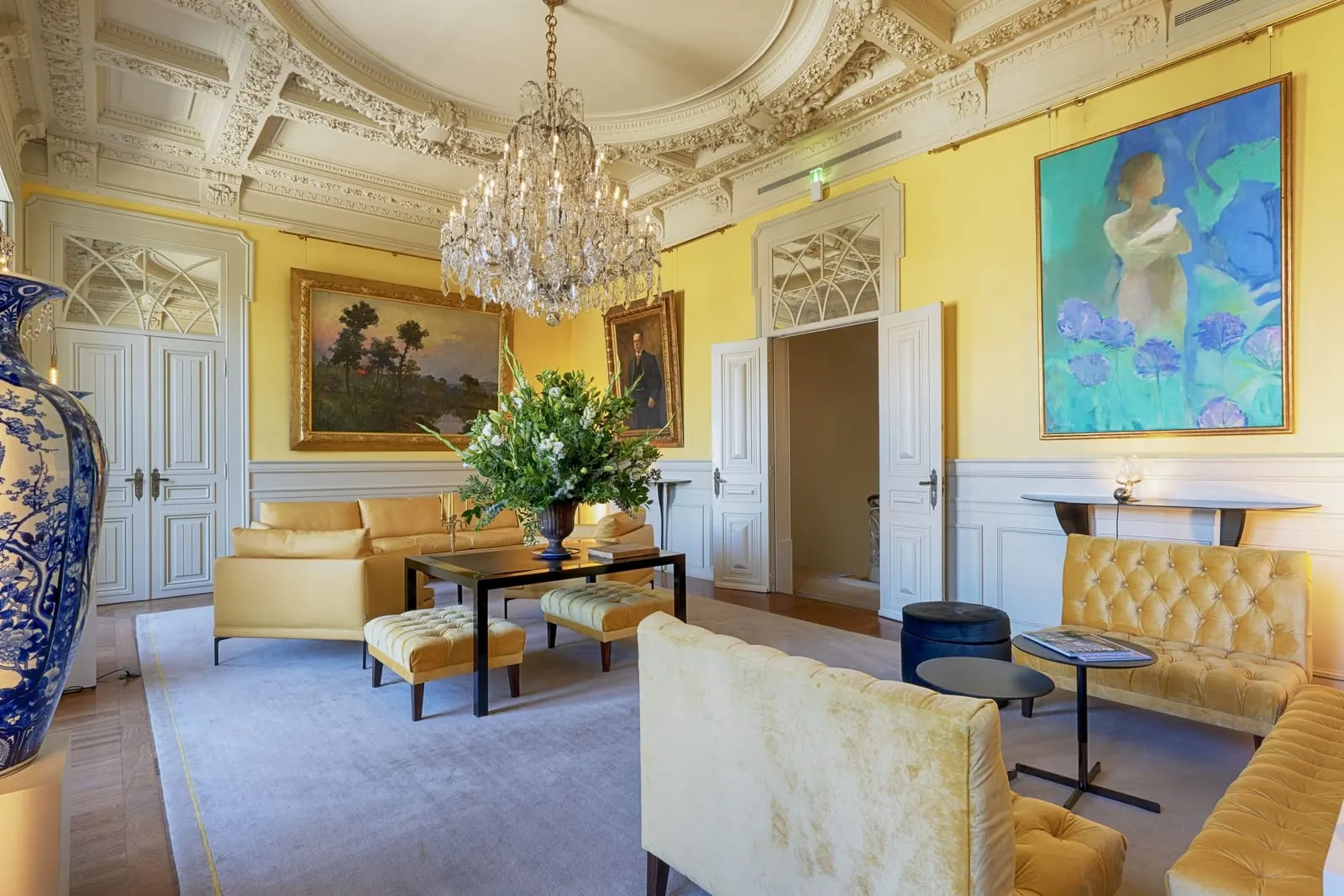The Yellow Room in the Royal Wing at Verride Palácio Santa Catarina: yellow velvet sofas, a chandelier and a stucco ceiling