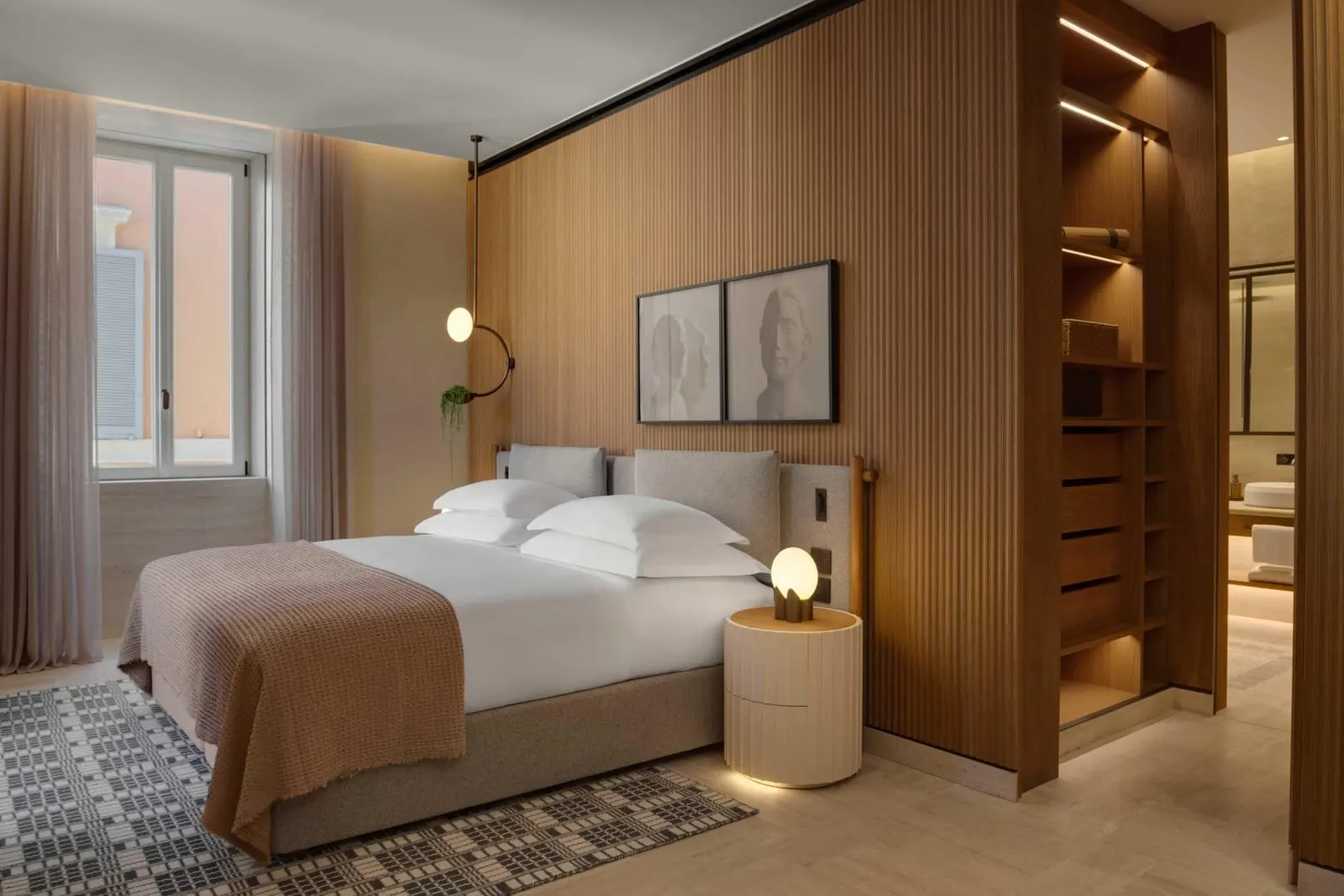 Junior Suite at Six Senses Rome: the bed against a slatted wood wall, beside an open dressing room