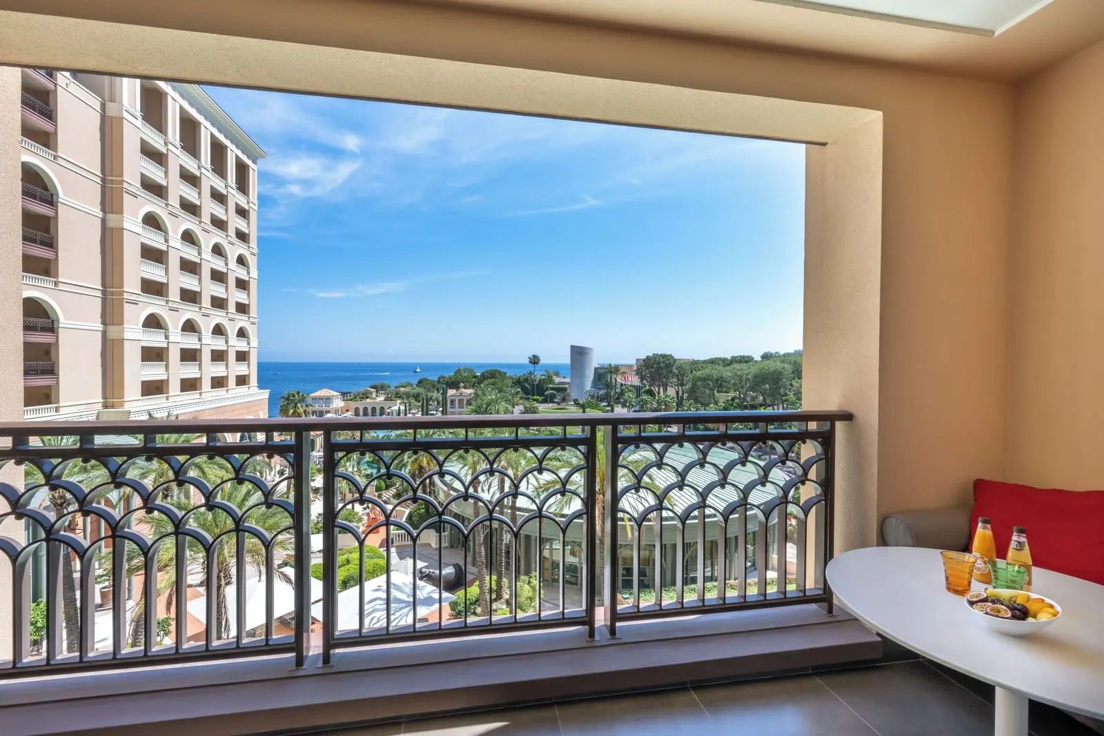 Exclusive Room with sea view at Monte-Carlo Bay Hotel & Resort: the terrace table, the gardens and the sea beyond the railing