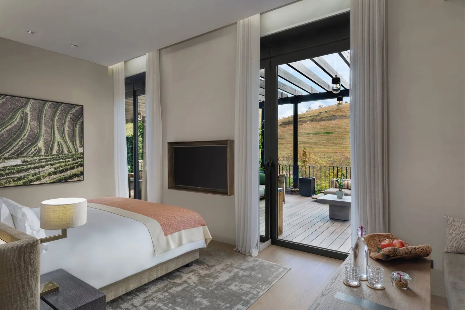 Vineyard Deluxe at Six Senses Douro Valley: the bed and glass doors open to a terrace under a pergola