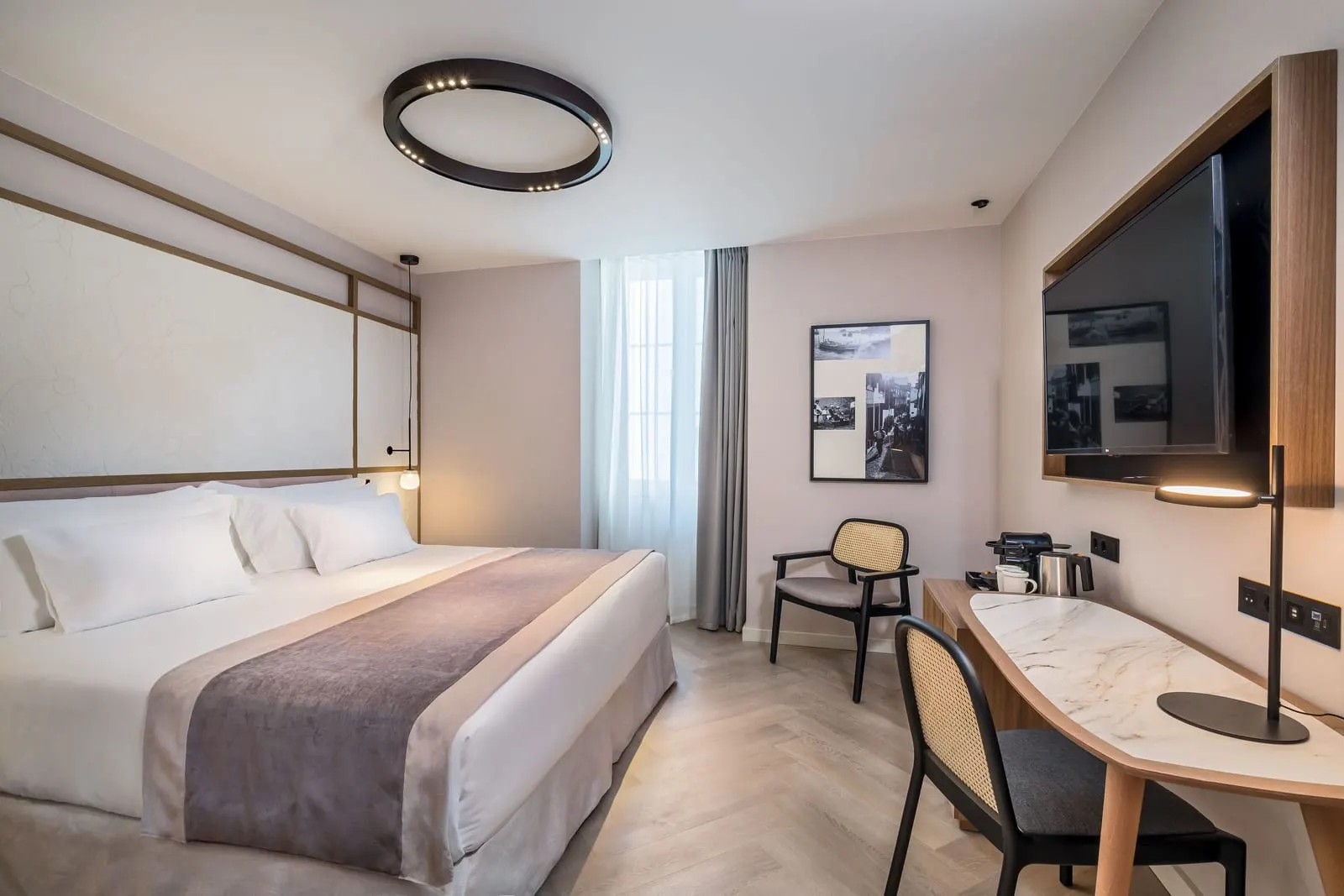 Deluxe at Barceló Funchal Oldtown: a double bed, an armchair by a curtained window and a marble-topped desk below a wall television