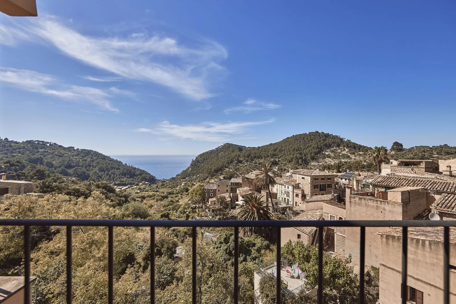 Dreaming Sea at Maristel Hotel & Spa: a balcony railing over village roofs and wooded hills, with a slice of sea between the ridges