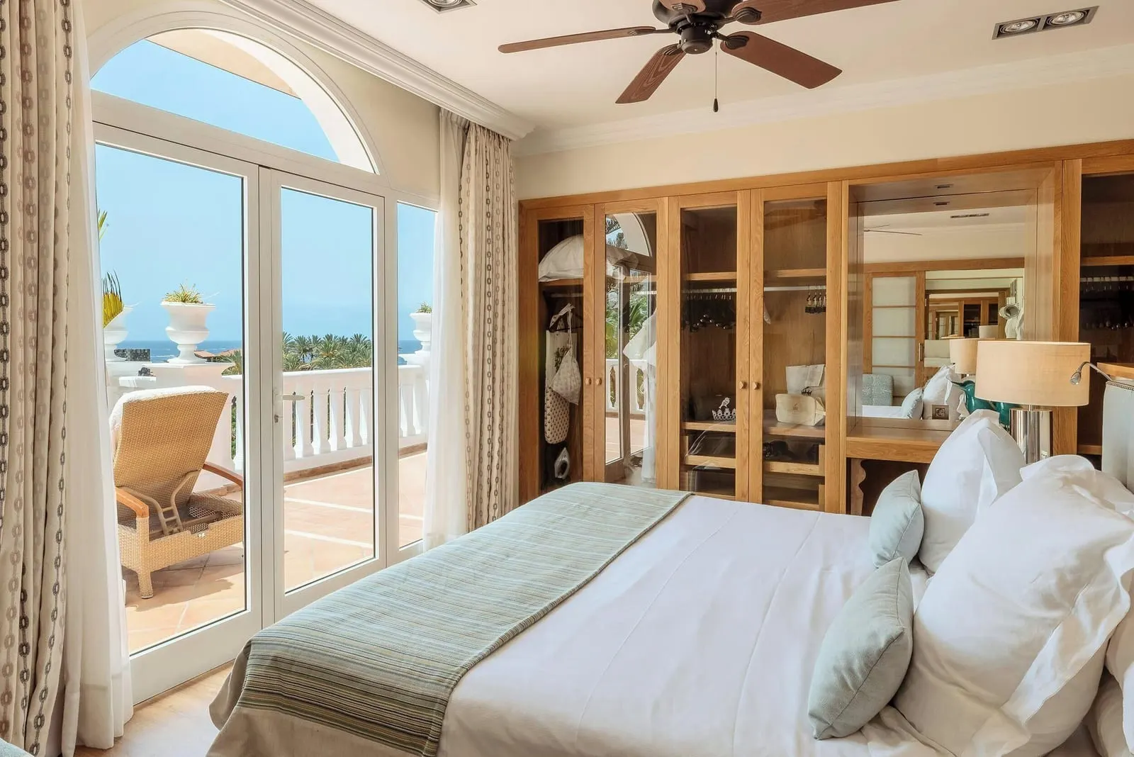 Casas Ducales Royal Suite at Bahía del Duque: the bed, glass-fronted wardrobes and arched doors to the terrace