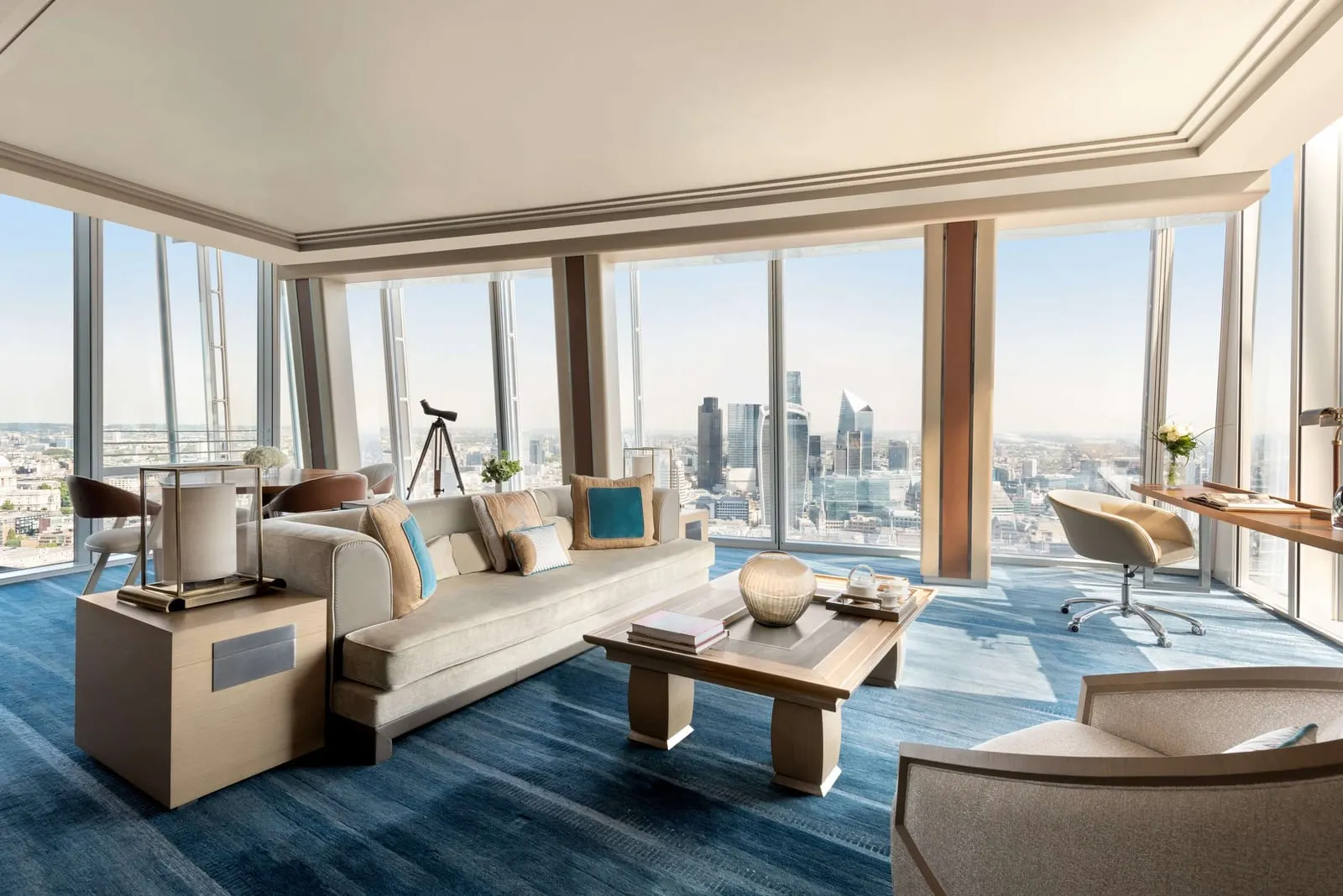 London Suite at Shangri-La The Shard: the lounge with sofas, a telescope and windows onto the City towers