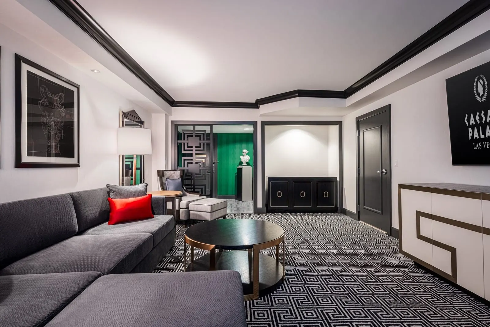 Colosseum Executive Suite im Caesars Palace: ein Wohnbereich mit einem grauen Sofa, einem runden Couchtisch, einem Sessel und einem Sideboard