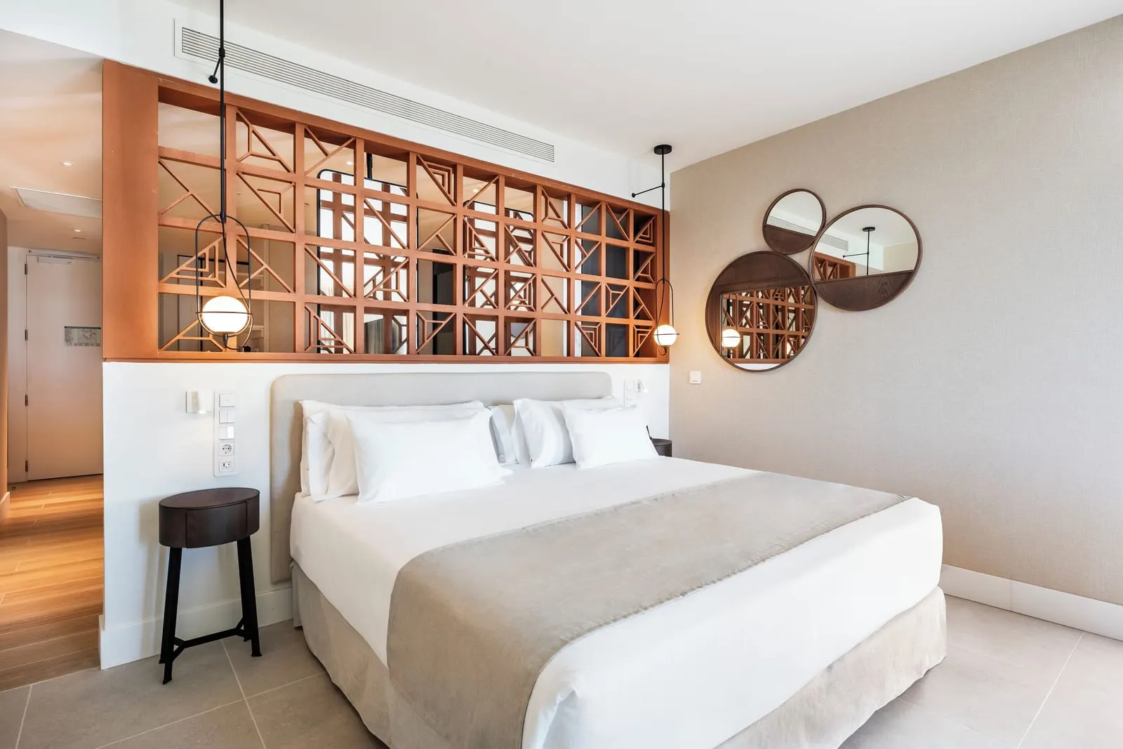 Junior Suite Sea View at Barceló Playa Blanca: a bed behind a timber lattice screen, with a stool and round mirrors