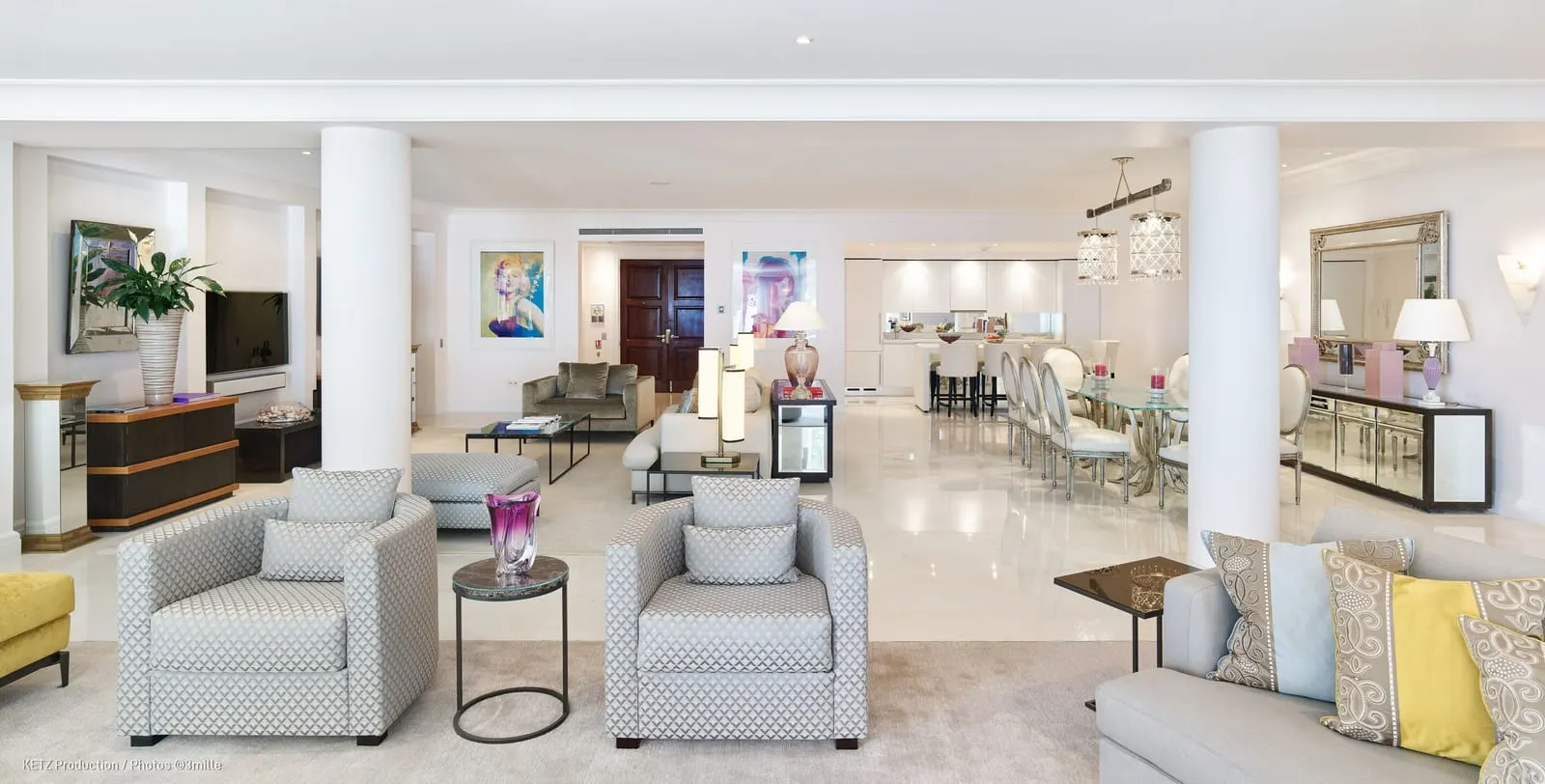 Presidential Suite 120 at Cap Estel: the long living room with armchairs, columns and a dining table beyond