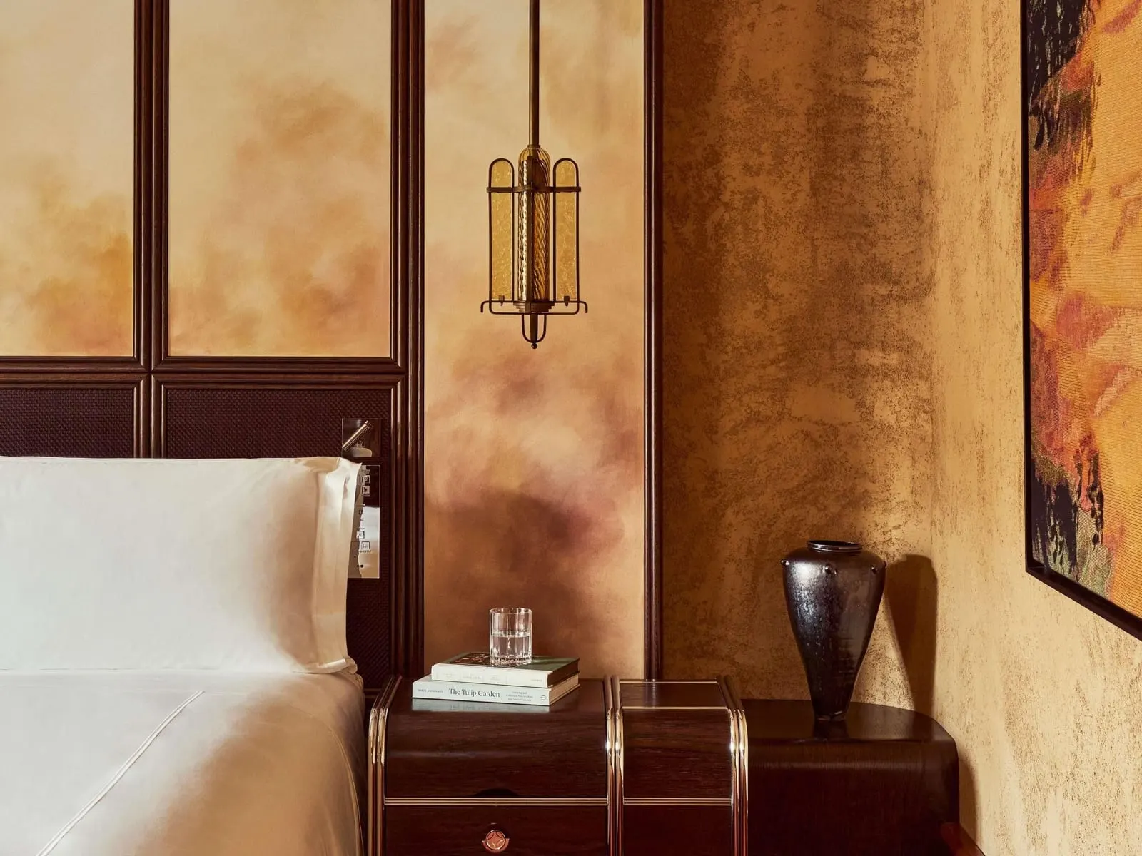 Superior Room at Orient Express La Minerva: the bed, a bedside table with a vase and a brass lantern