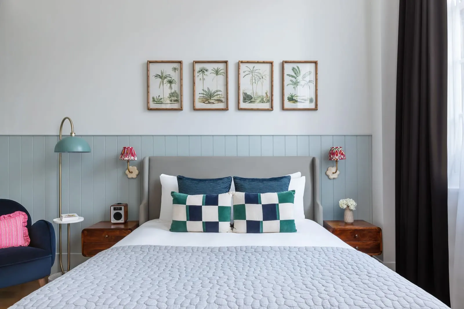 Junior Suite at Town Hall Hotel: the bed with checked cushions below four framed botanical prints