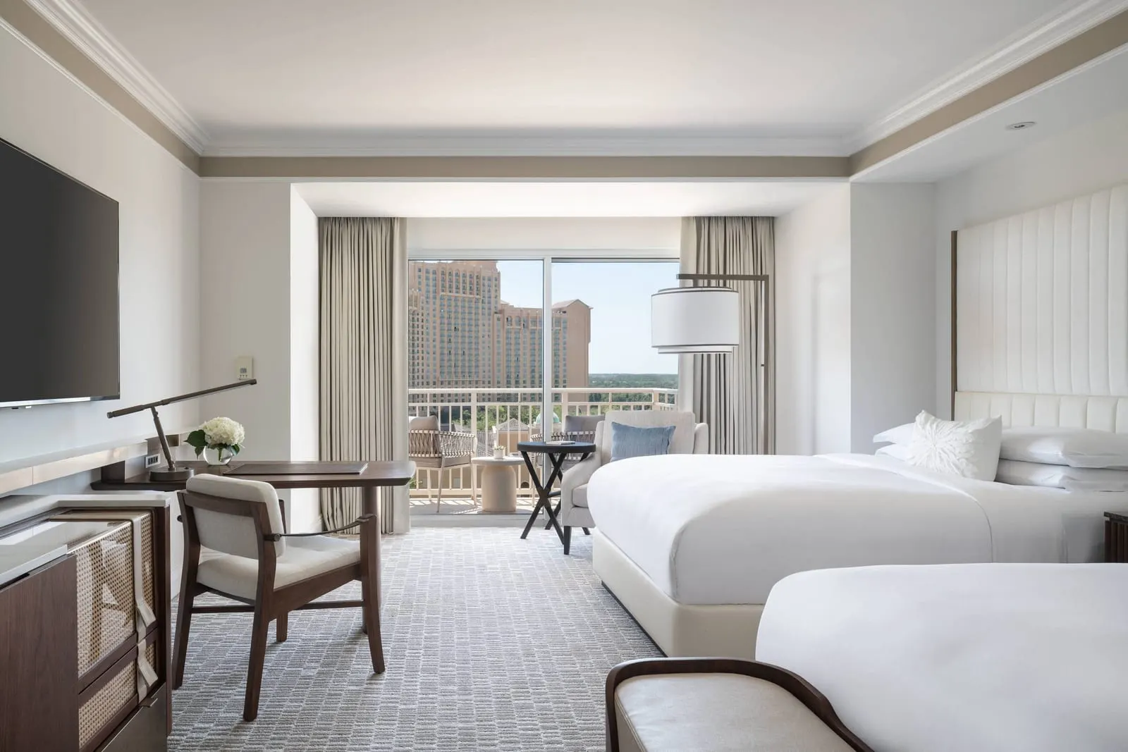 Resort View room at The Ritz-Carlton Orlando, Grande Lakes: two queen beds, a writing desk, an armchair and a sliding door onto the balcony