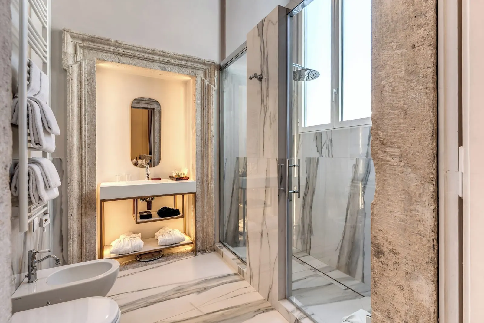 Deluxe Suite bathroom at Eitch Borromini Palazzo Pamphilj: a basin in a stone door frame and a marble walk-in shower