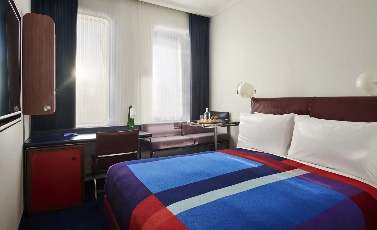 Standard Queen at The Standard, London: the bed with a striped blanket, a desk and a small sofa under the window