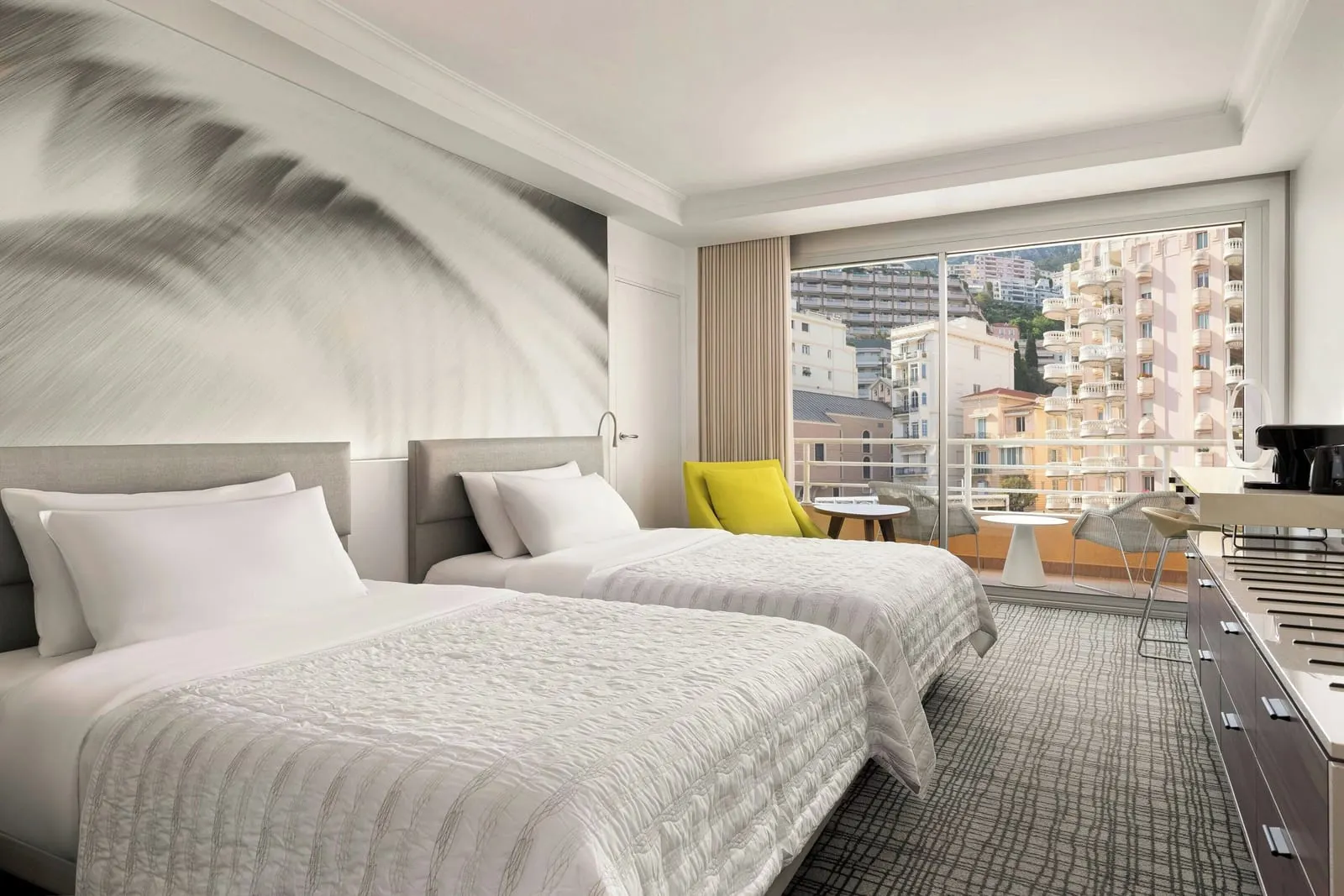 Superior room at Le Méridien Beach Plaza with two double beds and a window onto apartment buildings