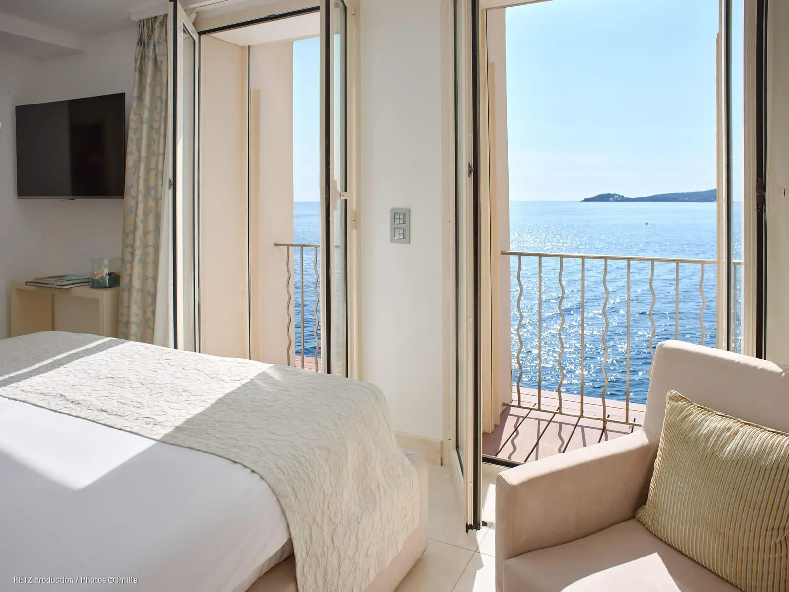 Le Parc Dream Duplex Suite 520 at Cap Estel: the bedroom, its French window open to a balcony over the sea
