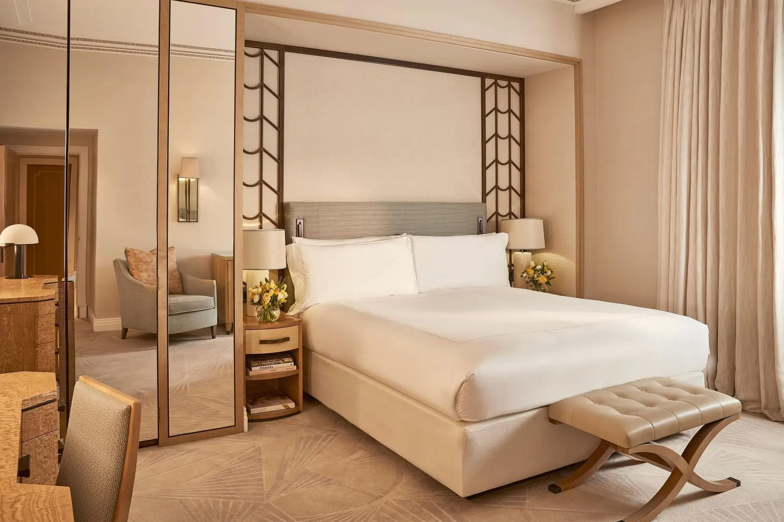 Superior Room at Claridge's: the bed between geometric screens, an upholstered bench and mirrored wardrobe doors