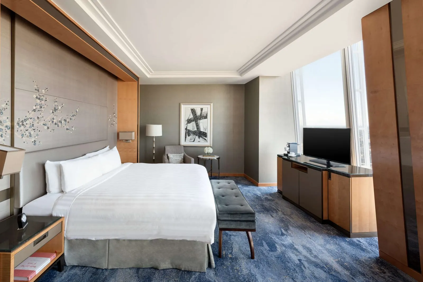 Superior Shard Room at Shangri-La The Shard: the bed with a padded bench, a television unit and a tall window