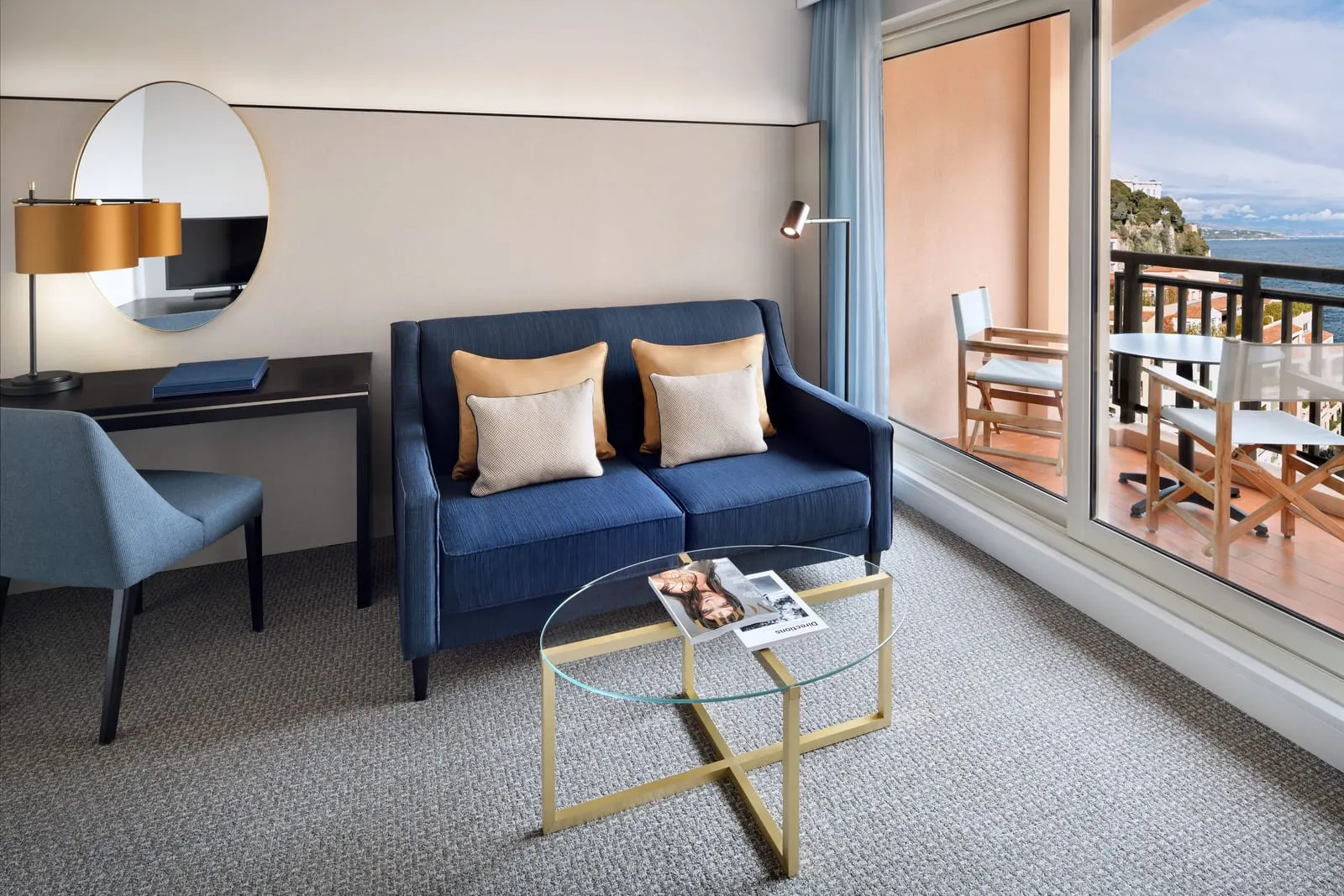 Riviera Suite at Columbus Hotel Monte-Carlo: the living area with a blue sofa and a terrace over the sea