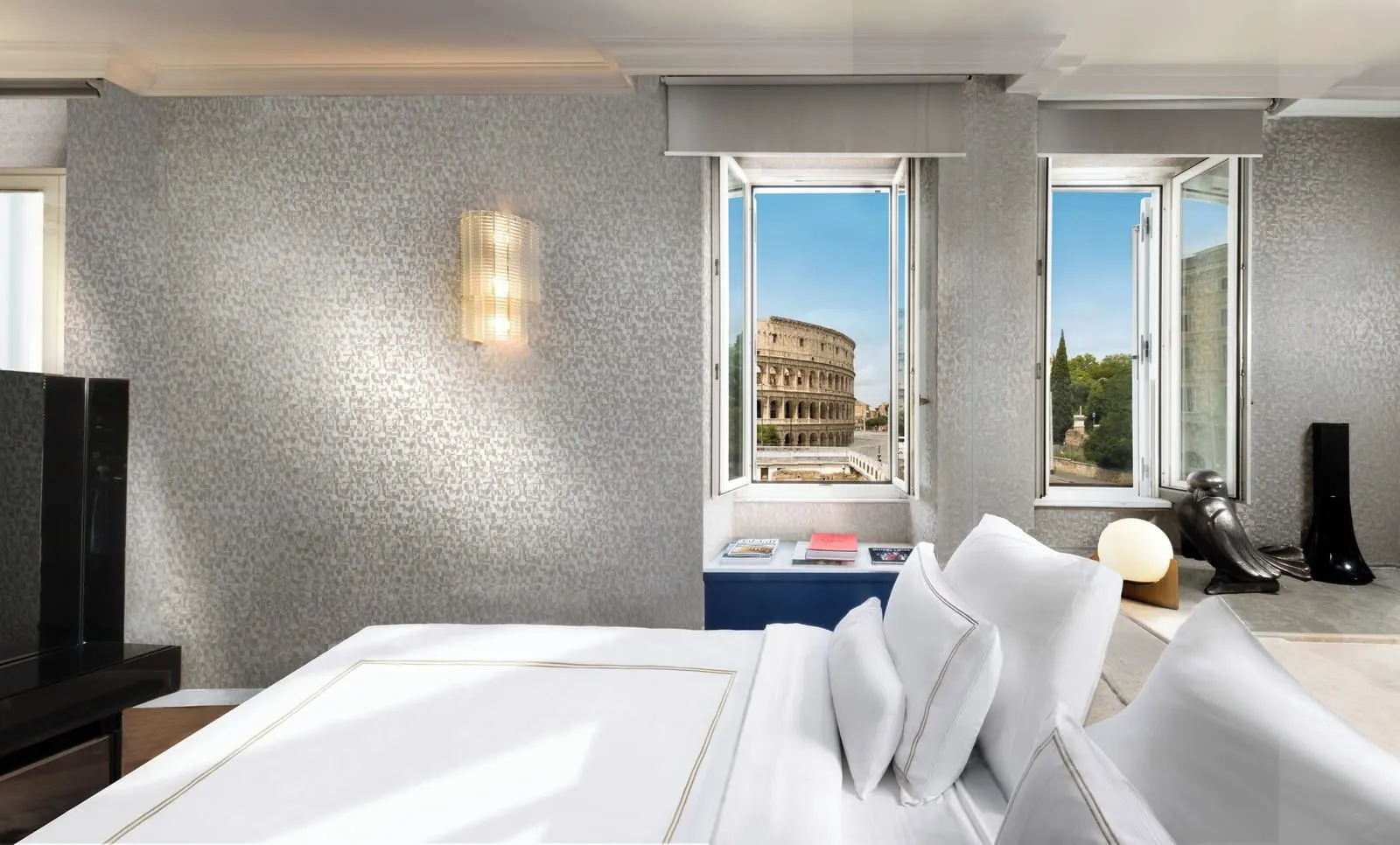 Colosseo Suite at Palazzo Manfredi: the bed facing two windows, the Colosseum in the left one
