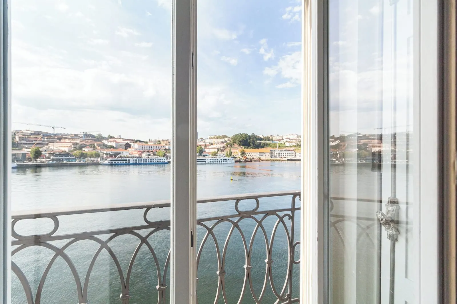 The Douro from a Superior Room with River View at 1872 River House: open windows, an iron balcony rail and the Gaia bank