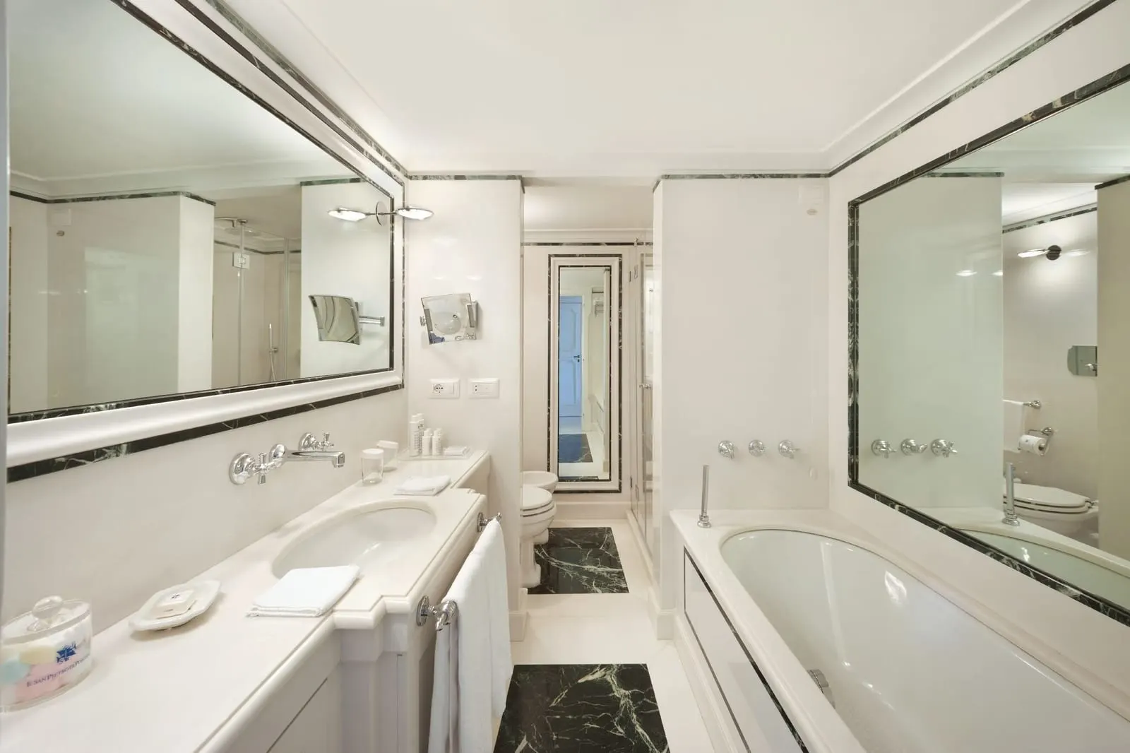 Elite Room at Il San Pietro di Positano: a white marble bathroom with a bath, a large mirror, a vanity and a separate shower