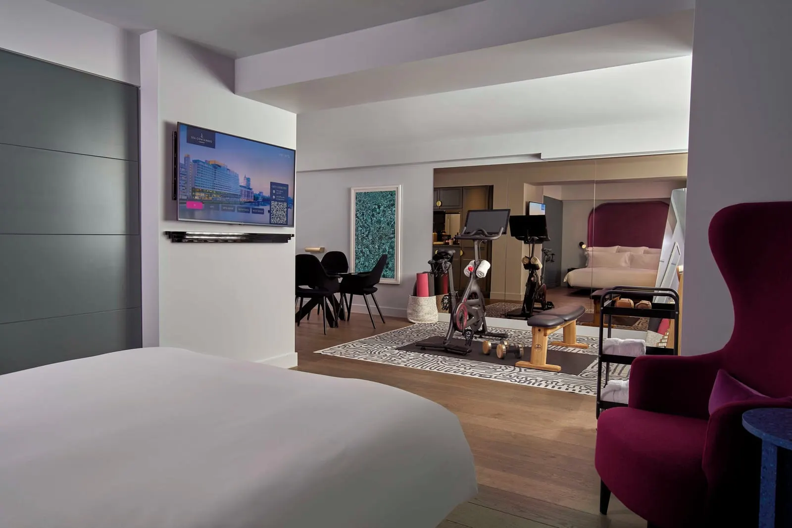Ship Shape Suite at Sea Containers London: the bed, a red wing chair, and an exercise bike and bench beyond