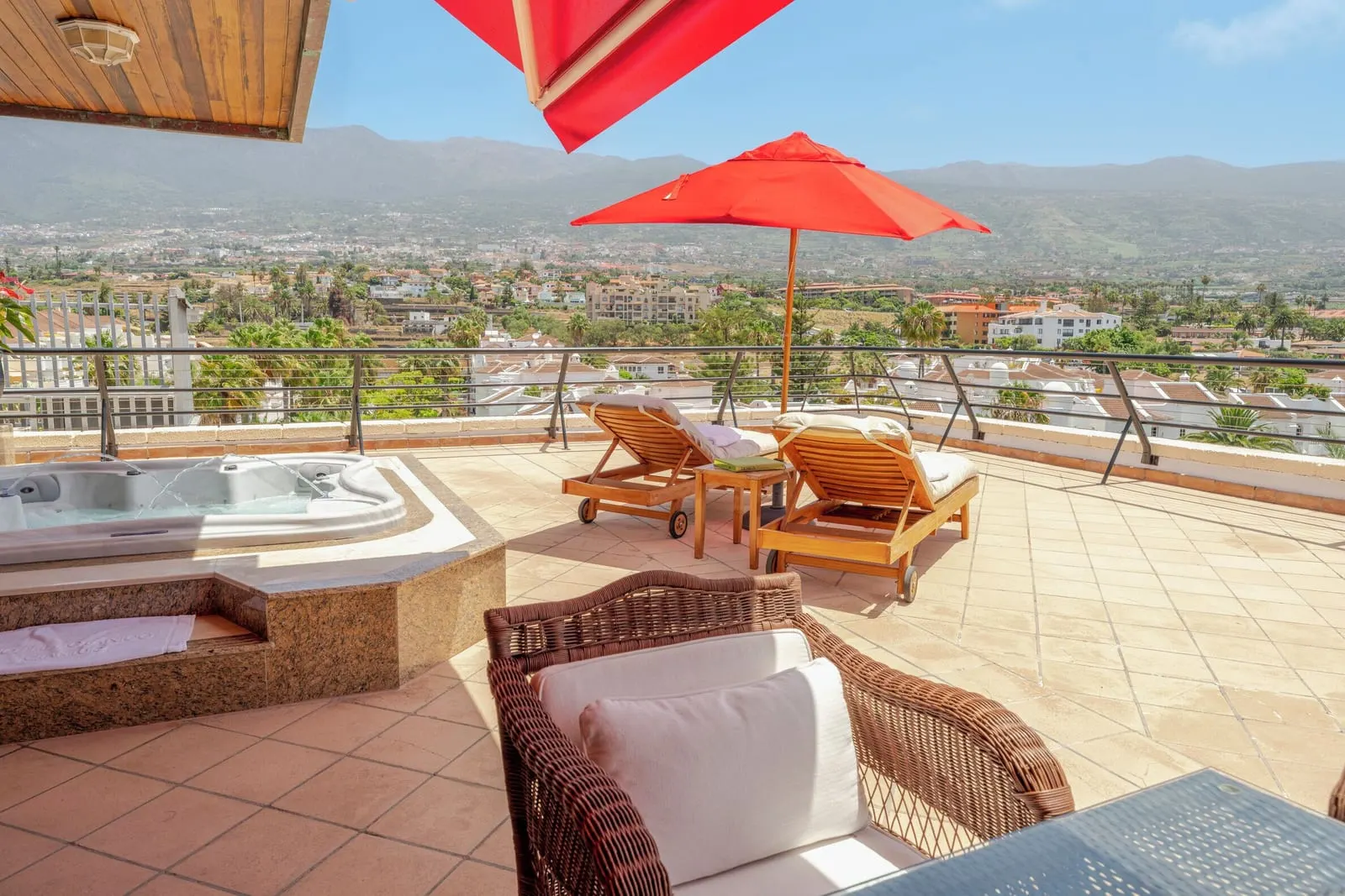Michael Jackson Suite at Hotel Botánico: the terrace hot tub, two loungers and a red parasol above the town