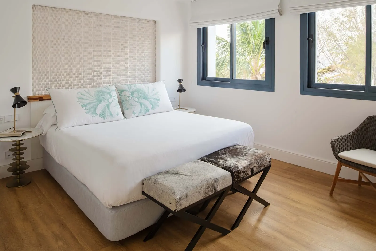 Grand Suite Fariones at Hotel Fariones: a king-size bed with a woven headboard wall, a stool at its foot and two windows