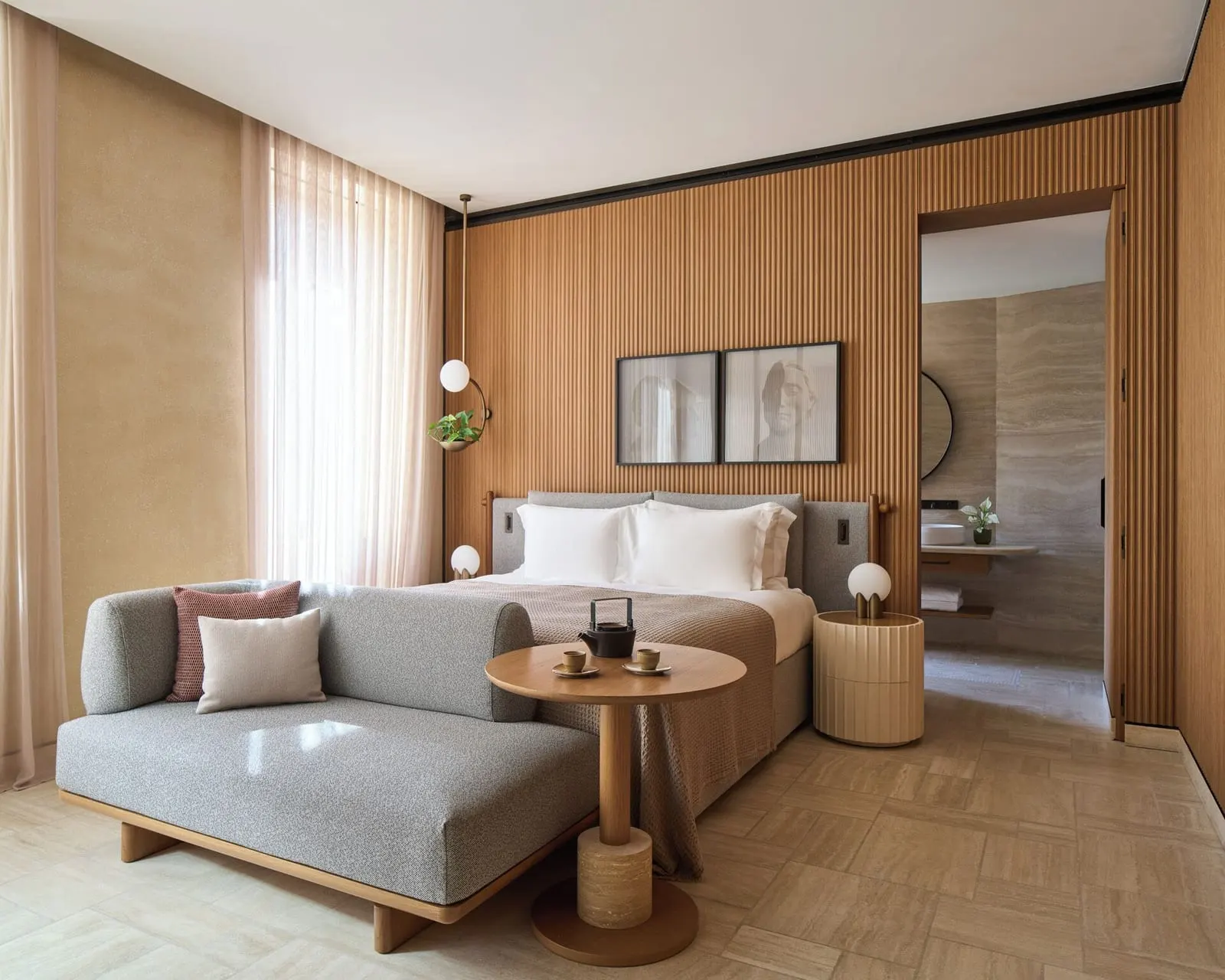 Superior Deluxe room at Six Senses Rome: a double bed, a grey daybed and a round table, with the bathroom beyond