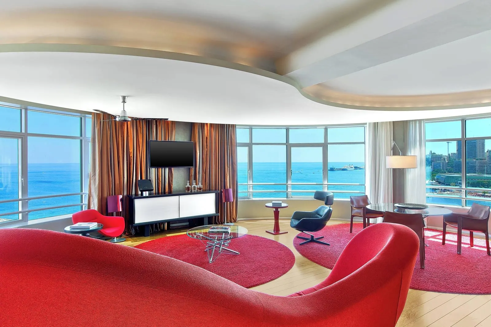Presidential Suite at Le Méridien Beach Plaza: the circular living room with a red sofa and windows onto the sea