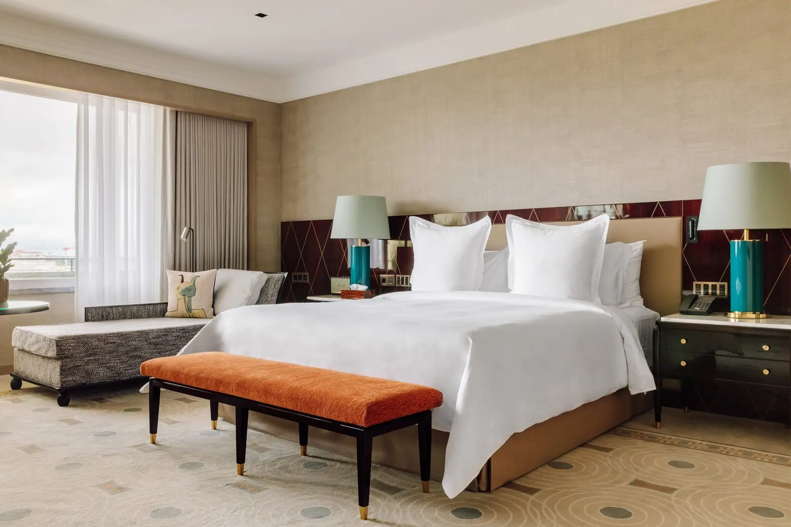 Deluxe Park-View Room at Four Seasons Ritz Lisbon: the bed with an orange bench, a daybed and tall windows