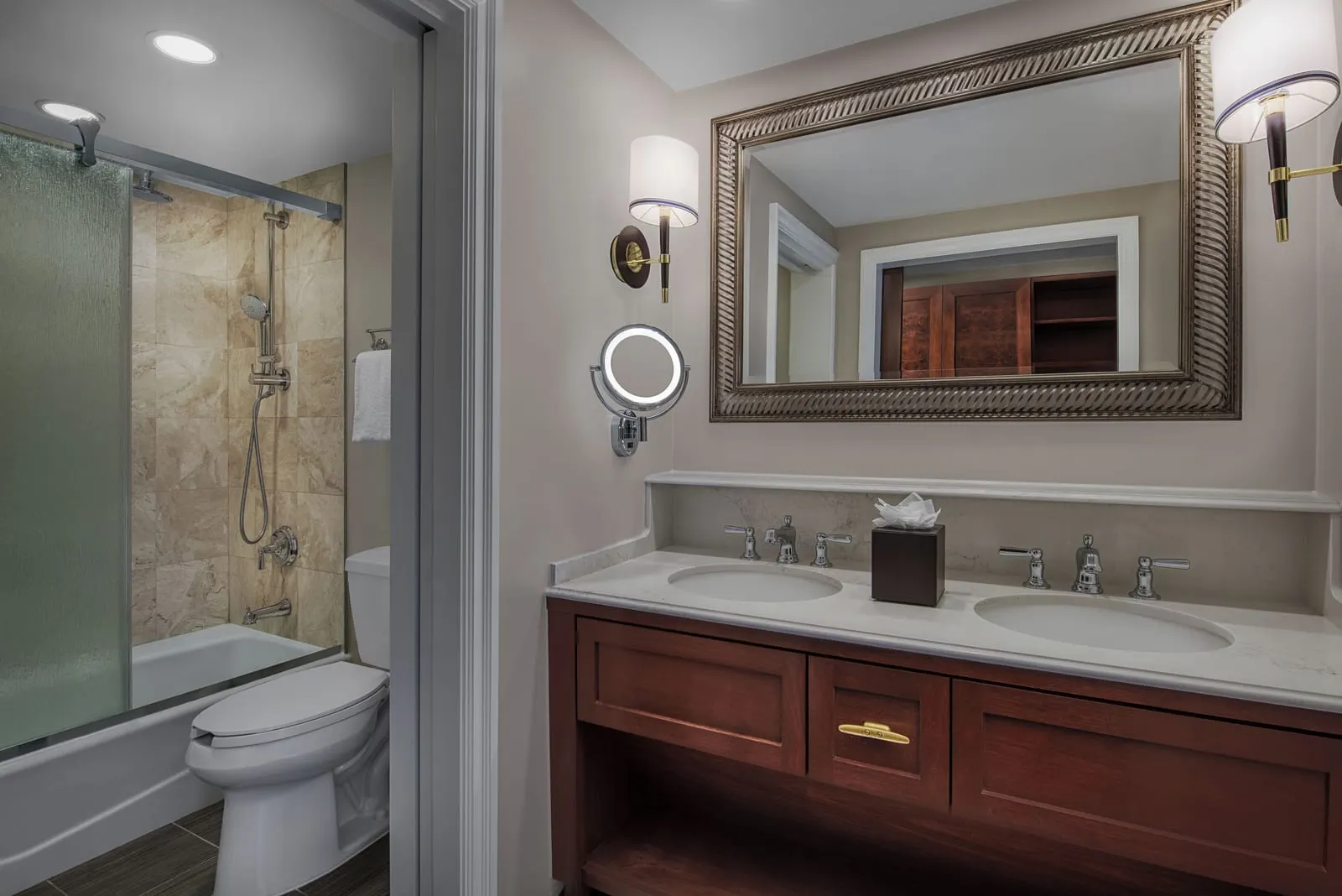 Water View room im Disney's Yacht Club Resort: das Badezimmer, mit einem Doppelwaschtisch, einem beleuchteten Schminkspiegel sowie einer separaten Toilette und gefliesten Badewanne mit Dusche