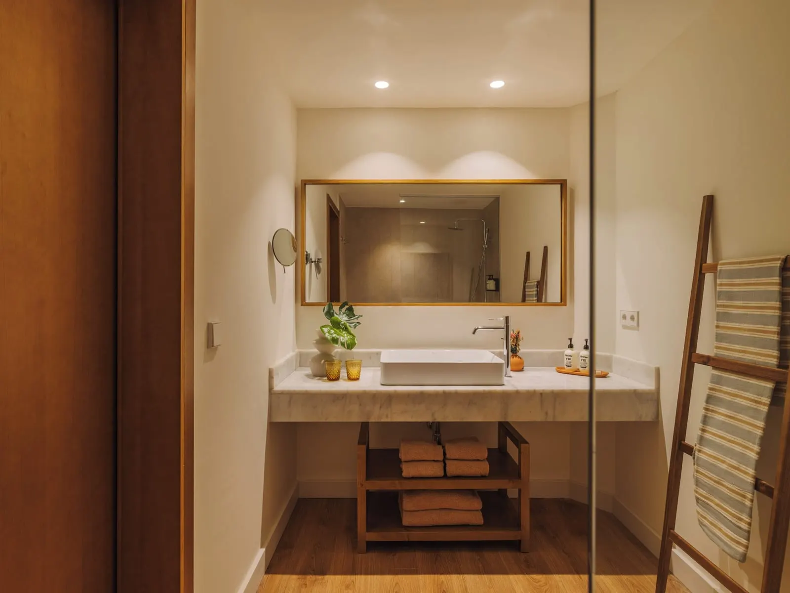 Suite at Paradisus by Meliá Fuerteventura: a bathroom with a marble counter, a basin, a wood-framed mirror and a towel ladder