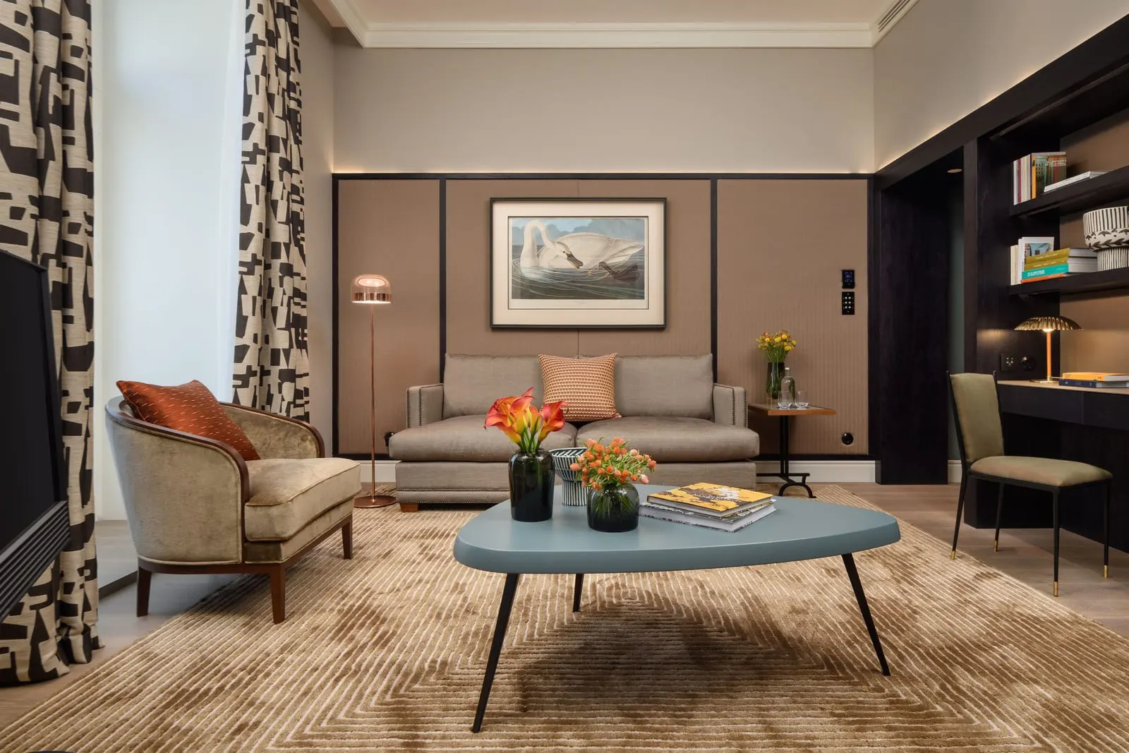 Tejo Suite at Bairro Alto Hotel: the living room, with a sofa, an armchair, a blue coffee table and bookshelves