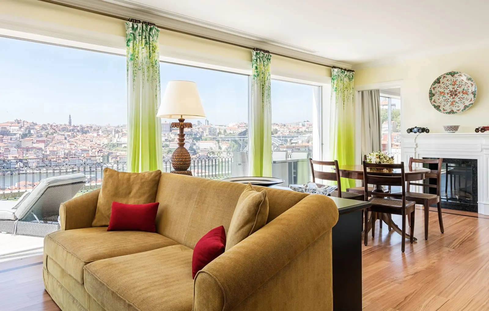 The Artist Suite at The Yeatman: a sofa, a dining table and a fireplace, with a wall of windows onto Porto