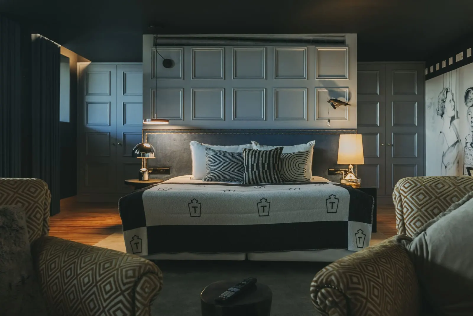 Maisonette at Torel Avantgarde: the bed against a panelled wall, with two patterned armchairs in front
