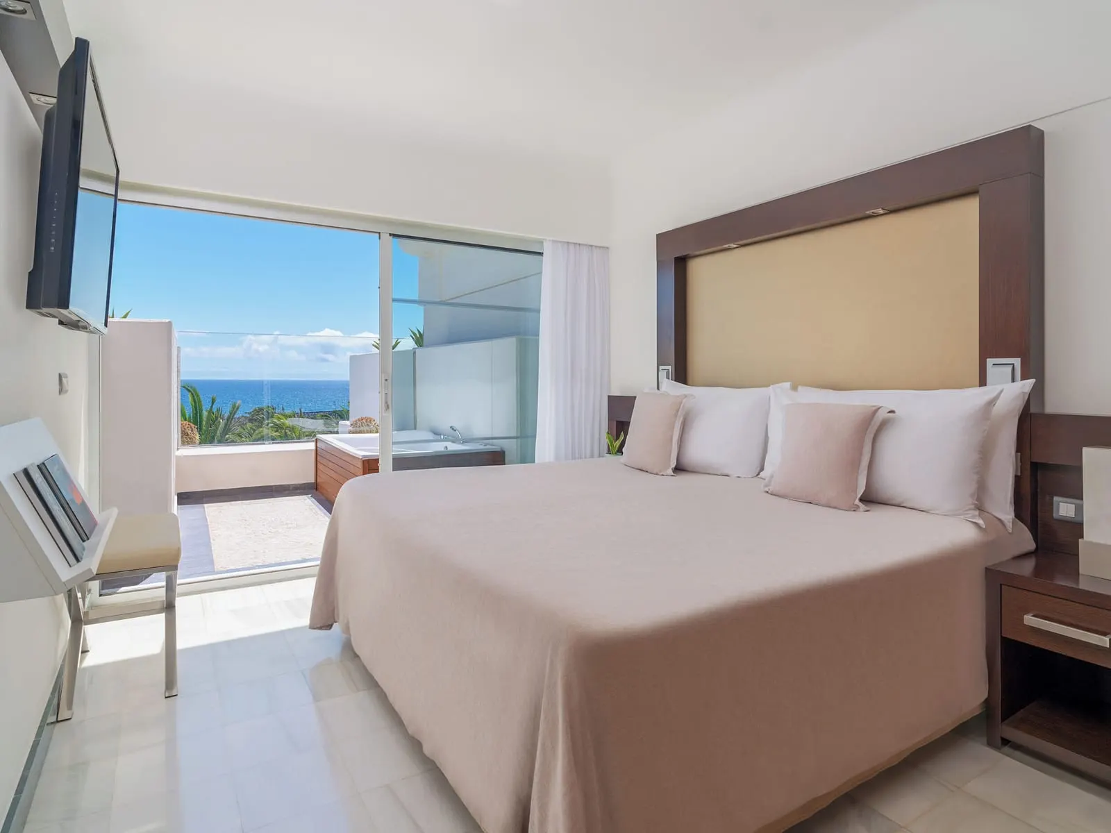 Oceanfront Suite with Whirlpool at Paradisus Salinas Lanzarote: a king bed with a headboard panel facing a window with a sea view