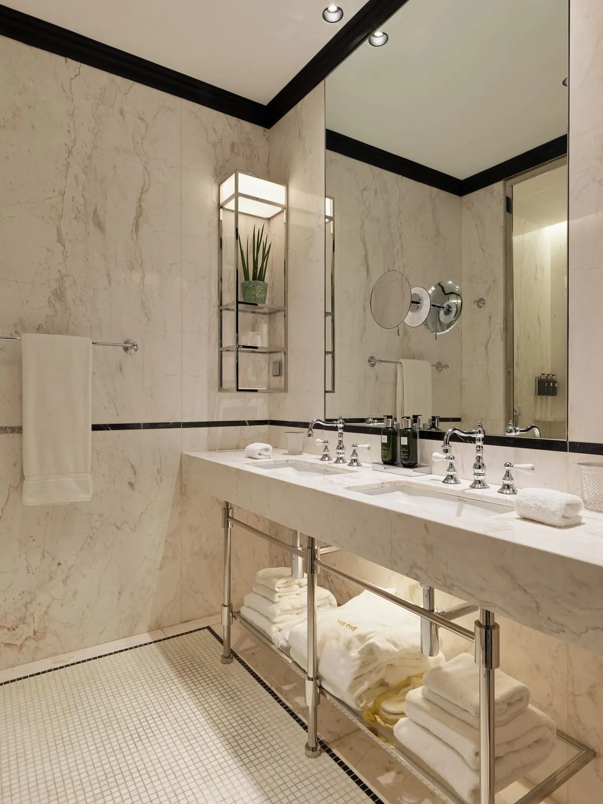 Grand Deluxe City Views bathroom at The One Monumental Palace: twin basins on a marble stand, a mirror and folded towels