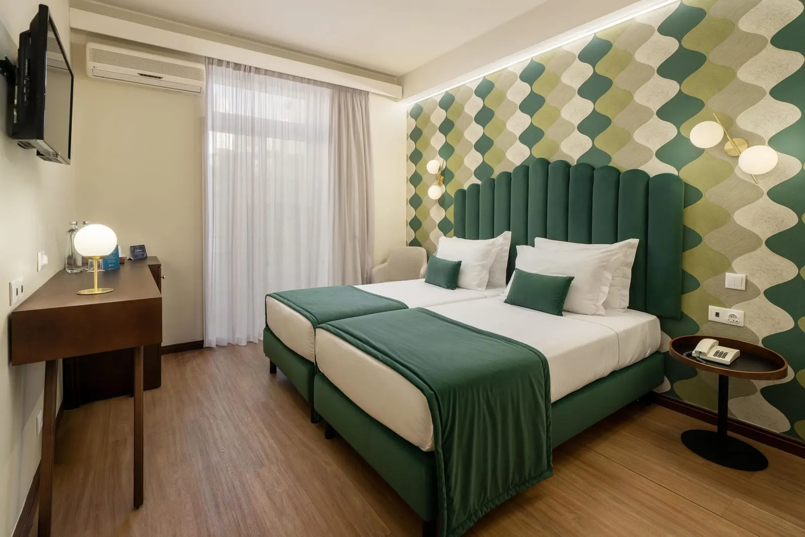 Hotel Madeira: A twin room with a green velvet headboard