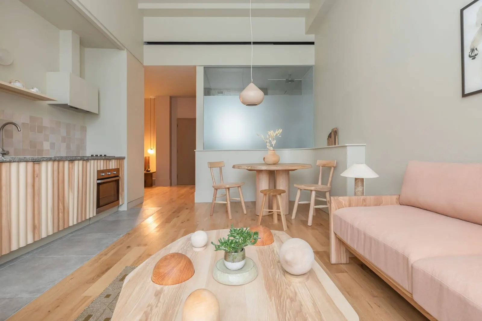 Signature Junior Suite at Town Hall Hotel: a kitchen along one wall, a round dining table and a pink sofa