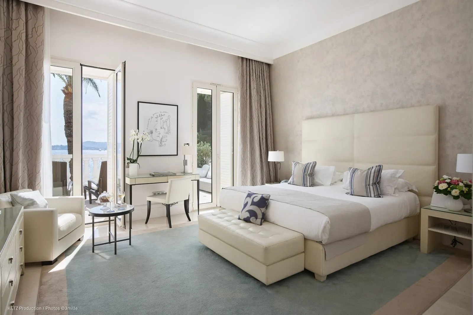 Deluxe Superior Room 221 at Cap Estel: the bed with a bench at its foot, a desk and French windows
