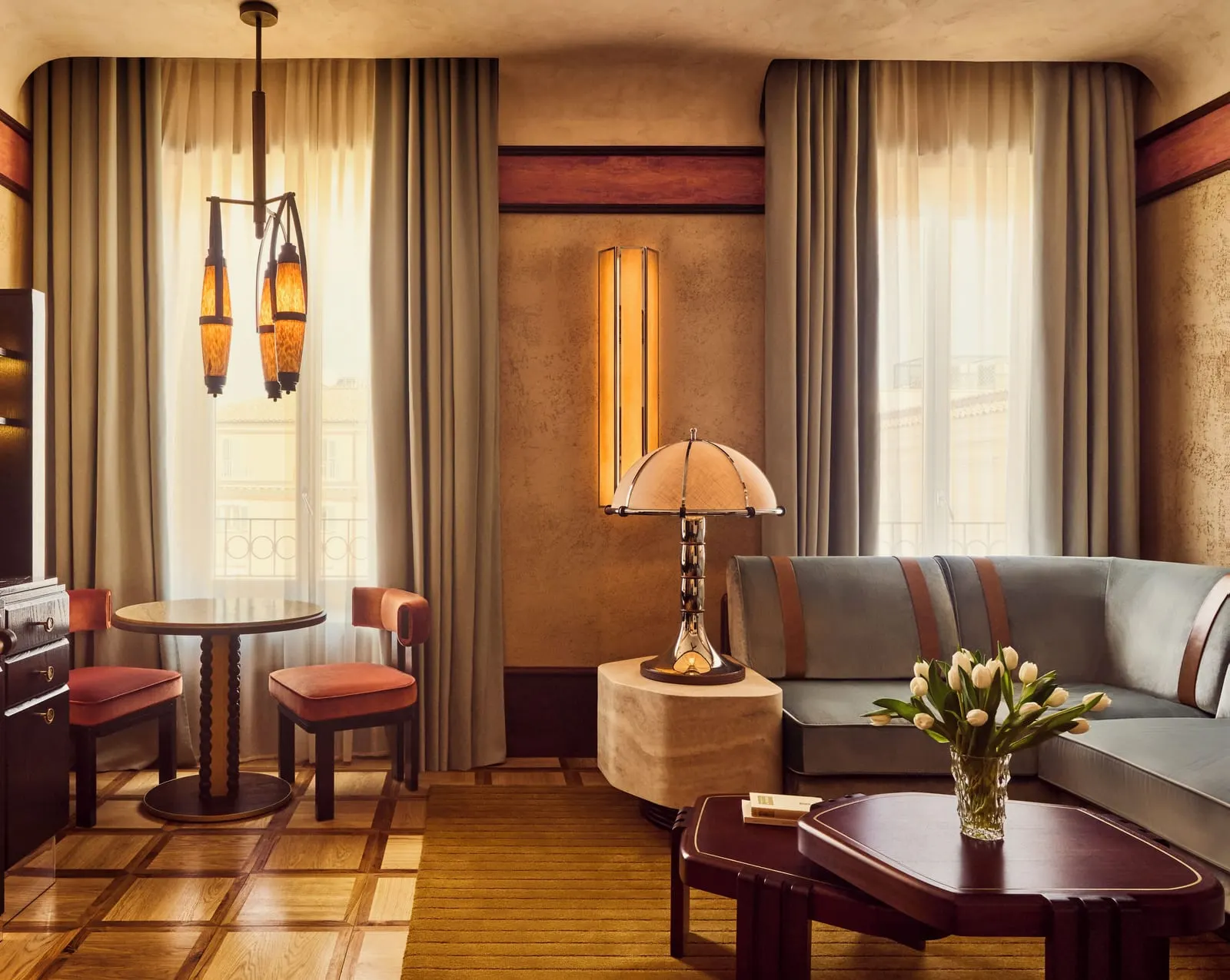 Grand Suite with View at Orient Express La Minerva: the living room with a sofa, a round table for two and tall windows
