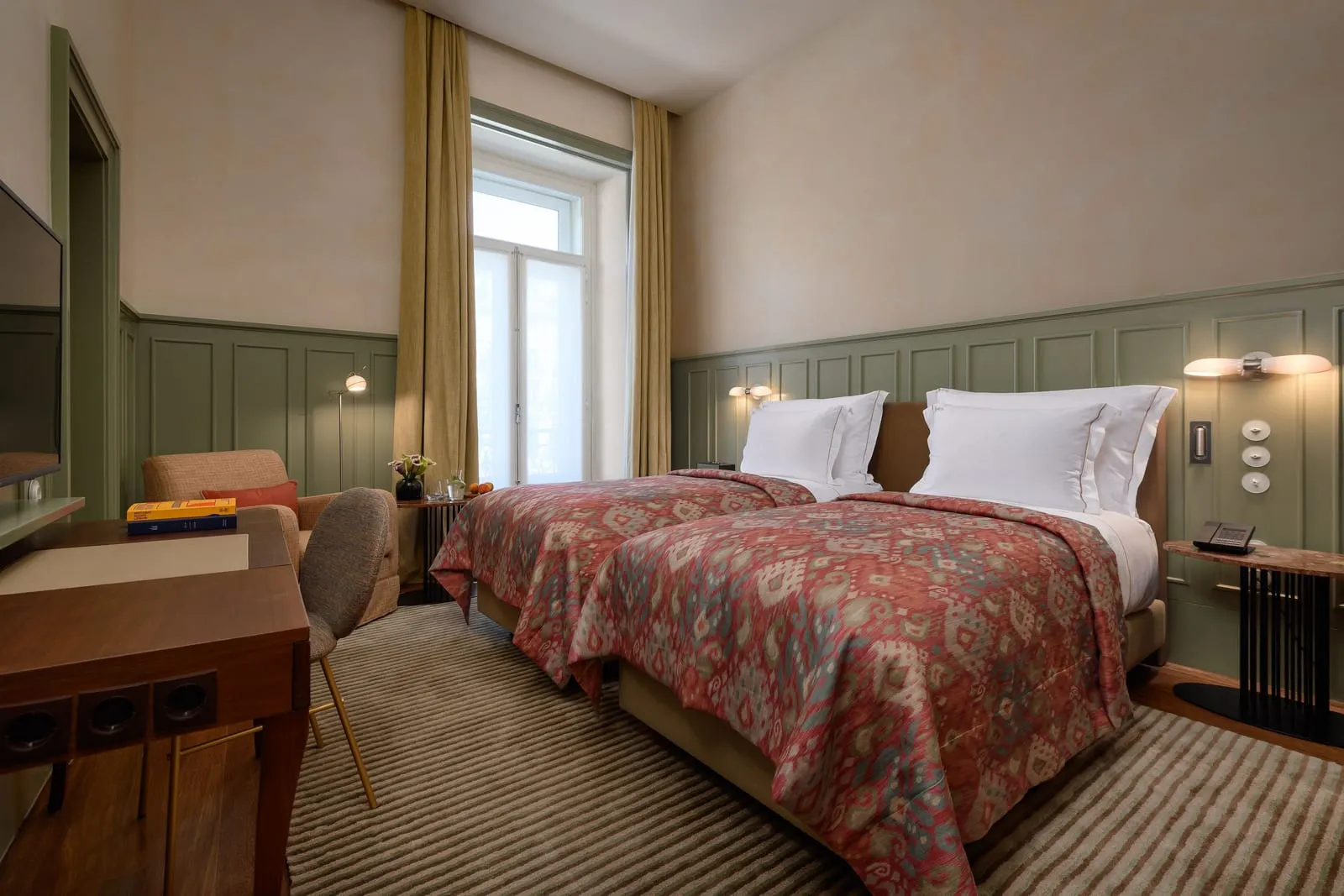 Classic Chiado Twin at Bairro Alto Hotel: two single beds with red throws, green panelling, a desk and a tall window